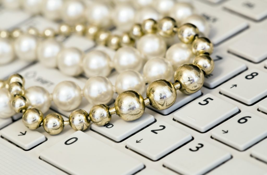 Female freelancing - pearls jewelry on a keyboard